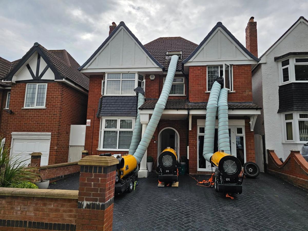 Professional bed bug heat treatment setup with multiple industrial heaters outside a detached house in the Midlands