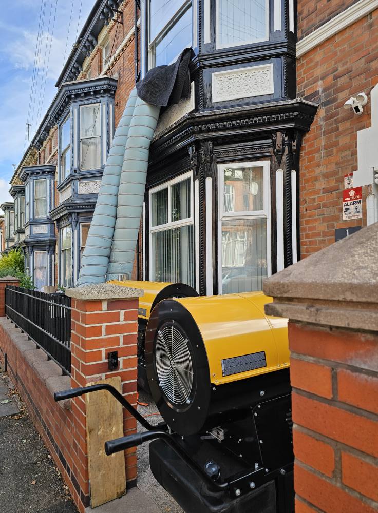 Heat treatment equipment positioned outside a Victorian terraced house in Leicester with ducting running to upper floor